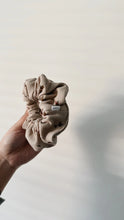 Load image into Gallery viewer, Baby scrunchie featuring a floral print on a ribbed beige fabric.