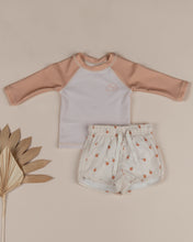 Load image into Gallery viewer, Beige baby rash-guard shirt with orange sleeves.