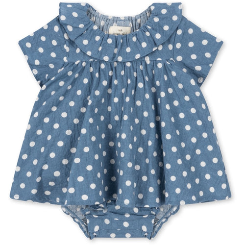 Blue baby romper with a ruffle neckline and a white polka dot all over print.