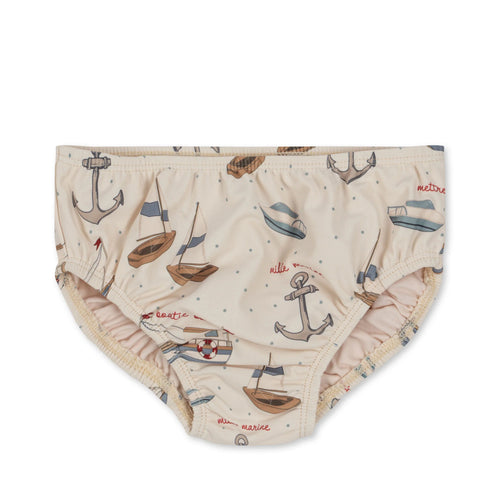 Beige coloured baby swim bloomers featuring an anchor, boat, and sailboat all over print. 