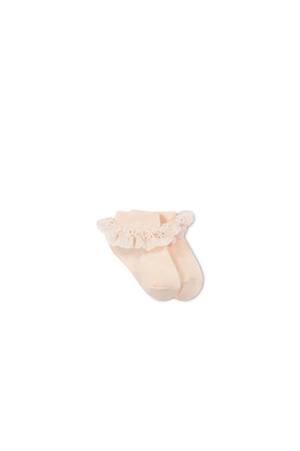Baby pink children's sock with a lace frill on the ankle. 