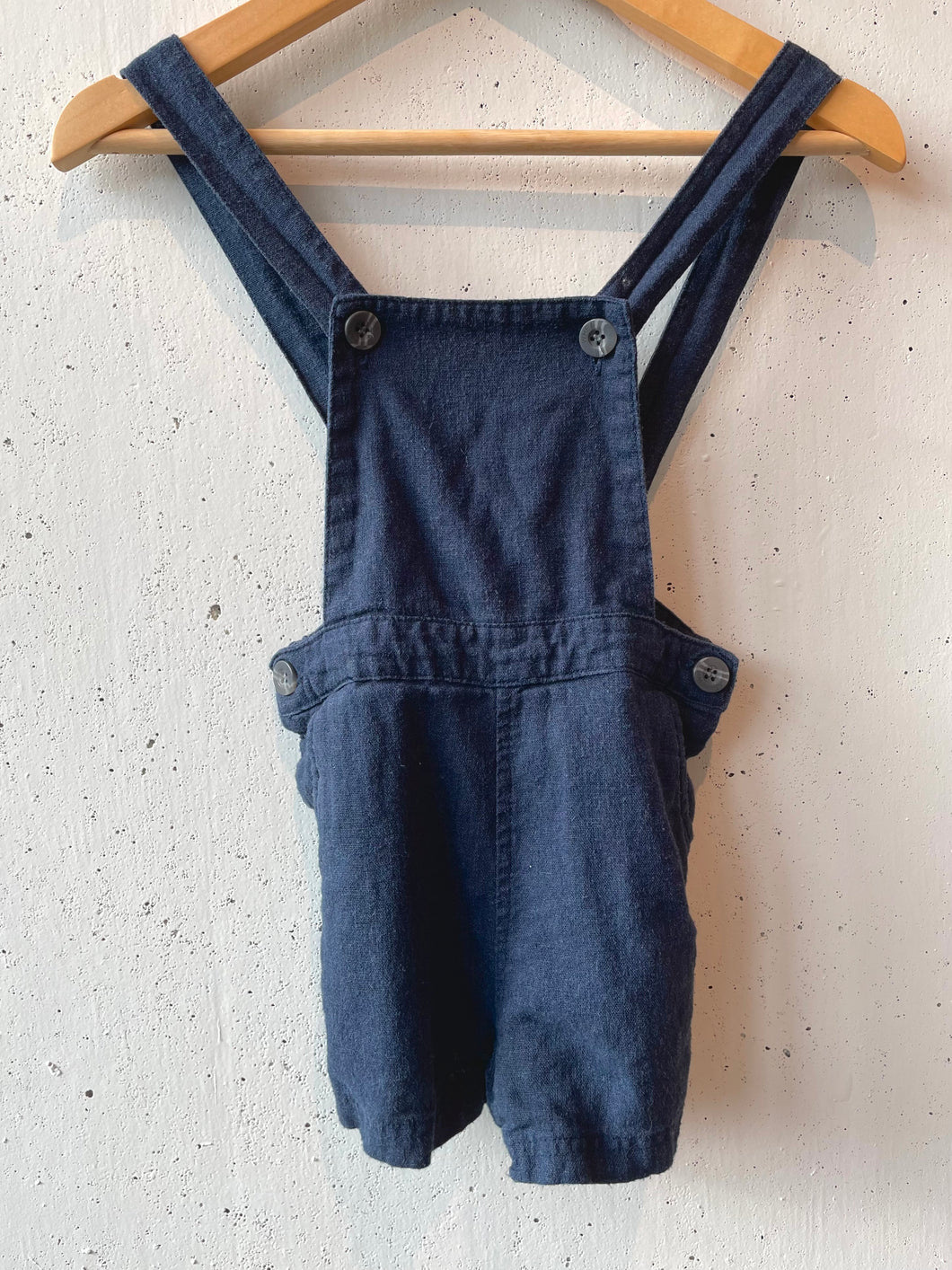 Navy blue linen overalls with button straps and waist. 