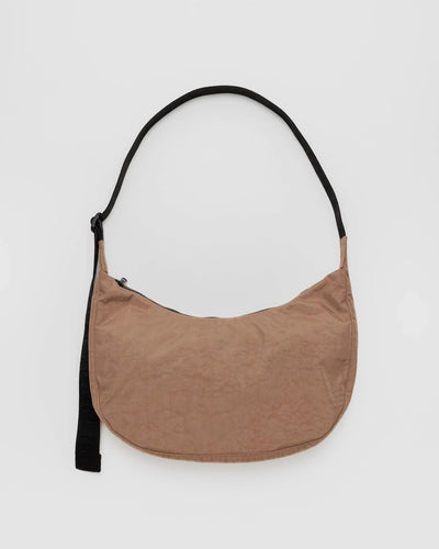 Beige crossbody crescent bag with a black strap. The whole bag is made of ripstop nylon. 