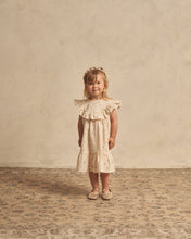 Load image into Gallery viewer, A-line neckline featuring a scoop ruffle and a ruffle at the bottom. The dress is featured in a pale yellow.
