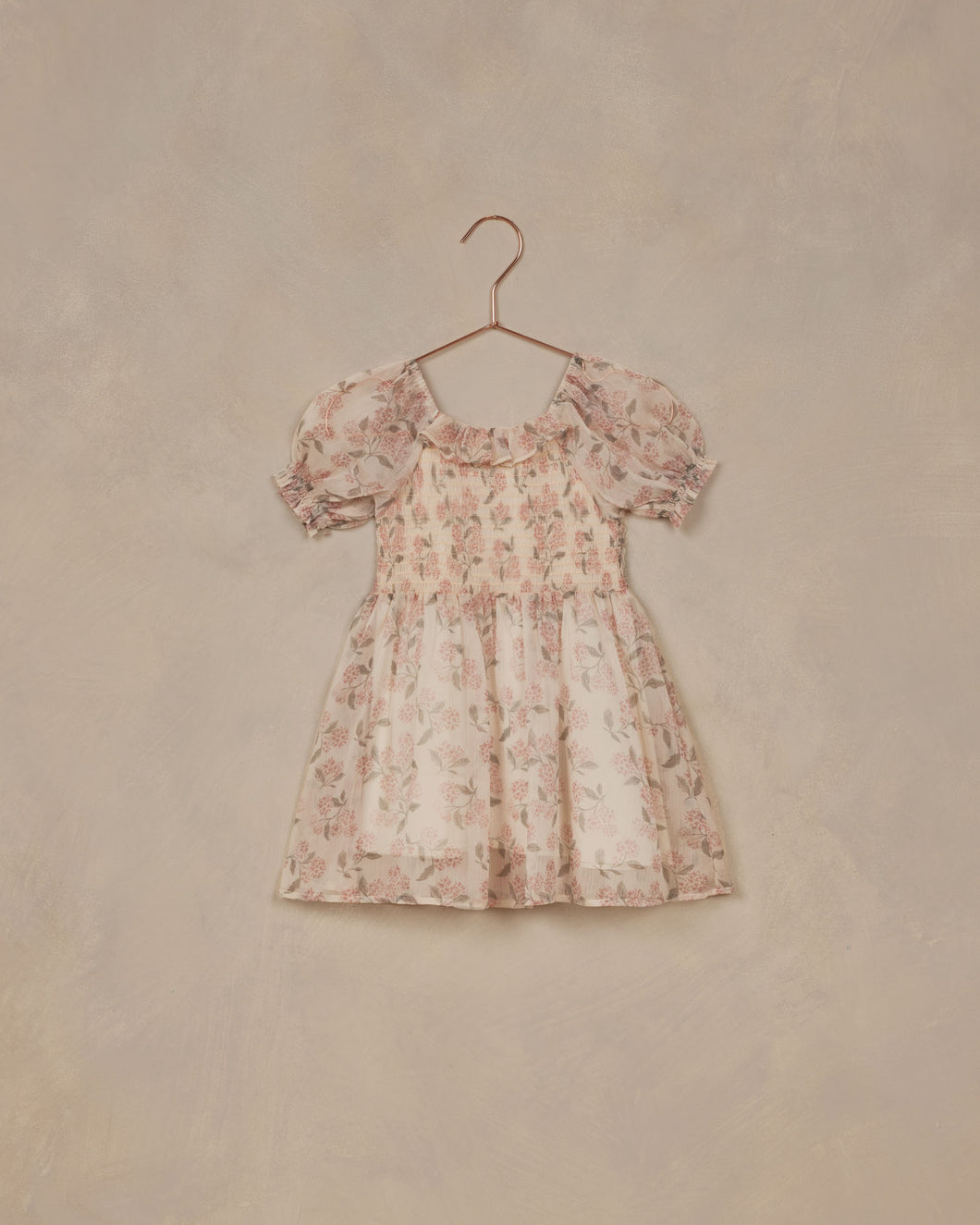 This vintage-inspired dress features a sweet chiffon, smocked bodice, and puff sleeves. The print is featuring a 'french hydrangea' all over print on an ivory base.