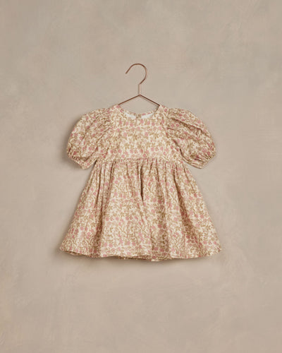 This dress features pretty puff sleeves and a babydoll inspired silhouette with a curved waistline. Scooped neck and button back closure. Featured in our 'wildflowers' all over print on our 'natural' hue.
