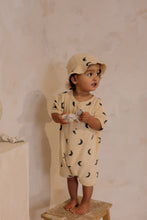 Load image into Gallery viewer,  Beige organic terry cotton romper with a dark blue moon print all over.
