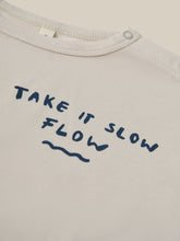 Load image into Gallery viewer, organic cotton white t-shirt with the words &quot;take it slow flow&quot; on the top left corner. 
