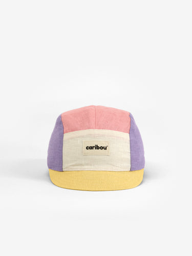 Baby cap featuring a five panel colour-block design. The colour-block design features a pink, purple, yellow, and cream.