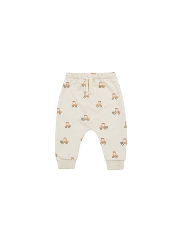 Beige coloured baby sweatpants with a tractor all over print. 