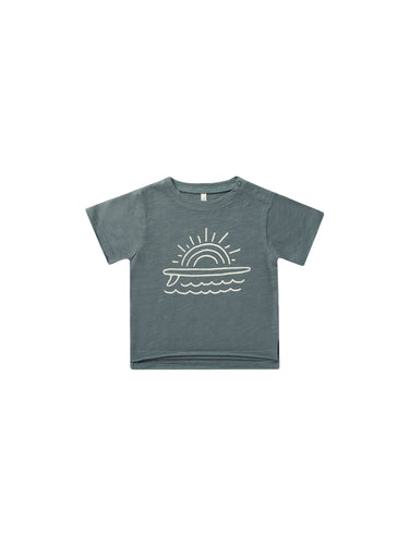 Indigo organic cotton tee featuring a surfboard, waves, and the sun as a graphic. 
