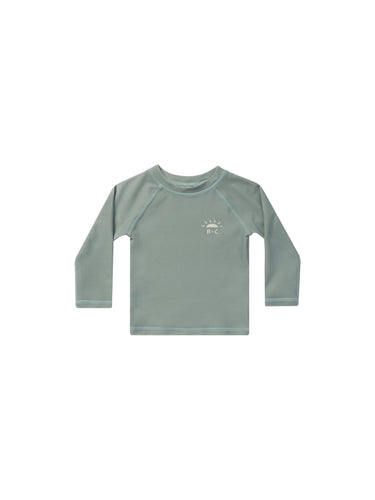 Long Sleeve swim rash guard featured in the colour Aqua and a sun and R + C in the top left side. 