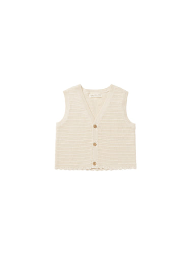 This sleeveless knit vest features buttons down the front and scalloped hem.  Featured in a beige.