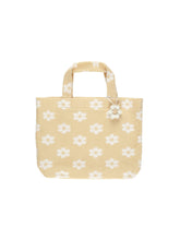 Load image into Gallery viewer, This beach bag is terry on the outside, woven liner on the inside, and a pom pom flower for extra flair. This bag is featuring a beige and white floral pattern. 
