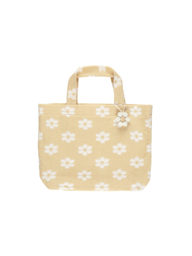 This beach bag is terry on the outside, woven liner on the inside, and a pom pom flower for extra flair. This bag is featuring a beige and white floral pattern. 