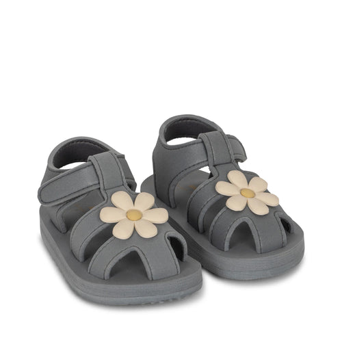 Navy Blue baby strappy sandals featuring a beige flower on the top.