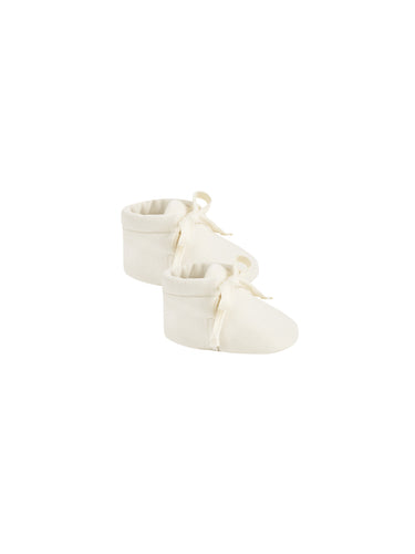Ivory baby booties in a soft and stretchy material with a tie for a secure fit. 