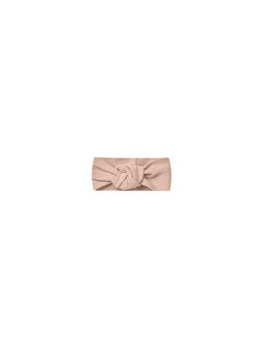 Knotted pink headband featured in a soft and stretchy material. 